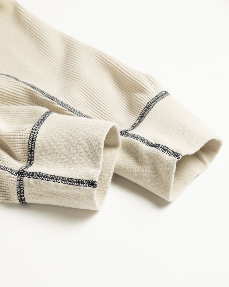 本体とは異なるカラーのステッチを配色としてデザインした中肉のベージュ色のワッフルロンT