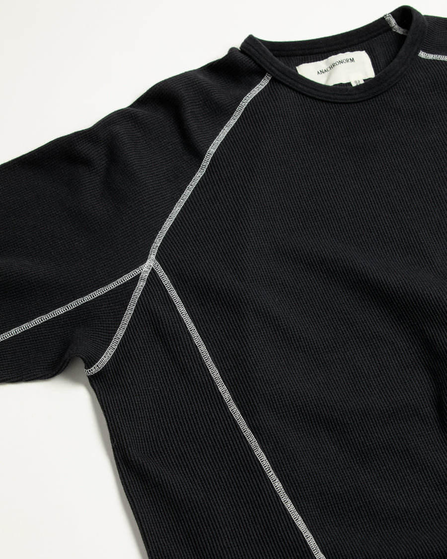 本体とは異なるカラーのステッチを配色としてデザインした中肉の黒色のワッフルロンT