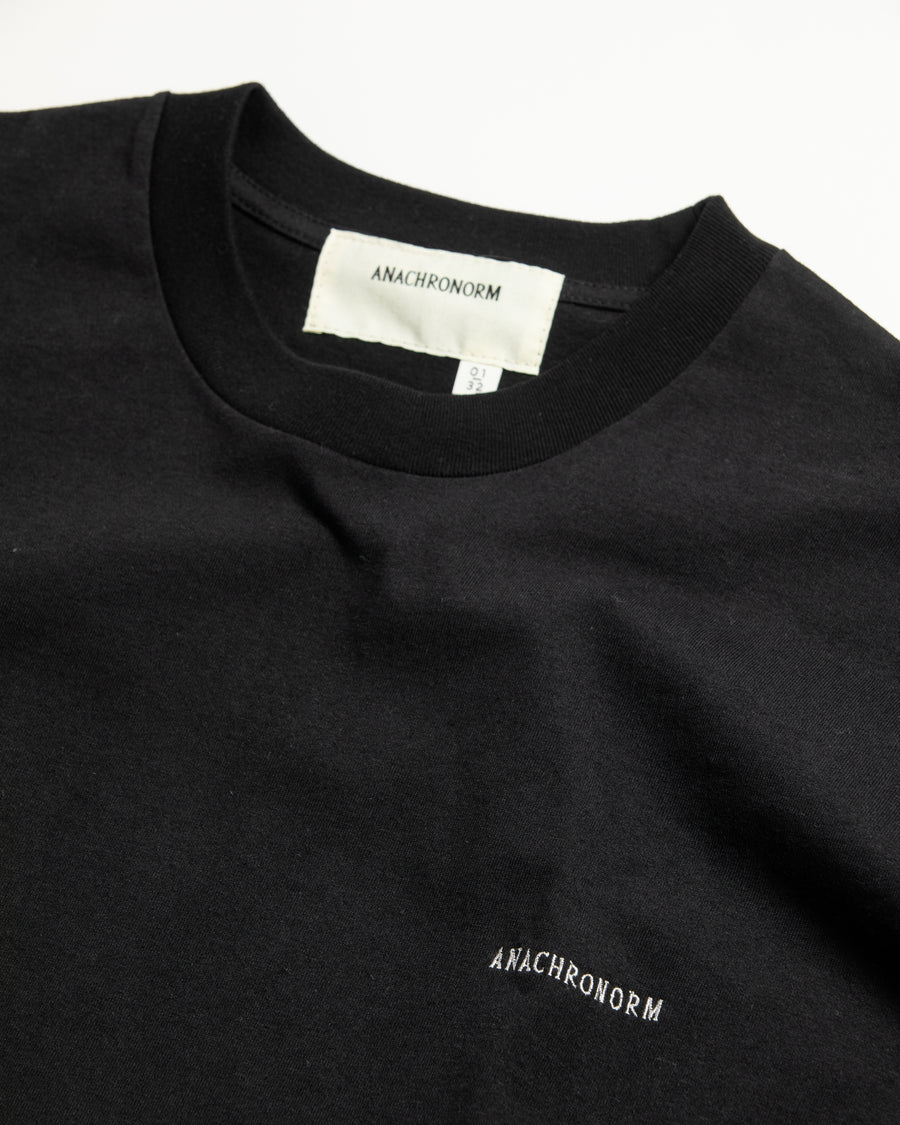 左胸にANACHRONORMのミニ刺繍が入っているベーシックな黒色のロングスリーブTシャツ