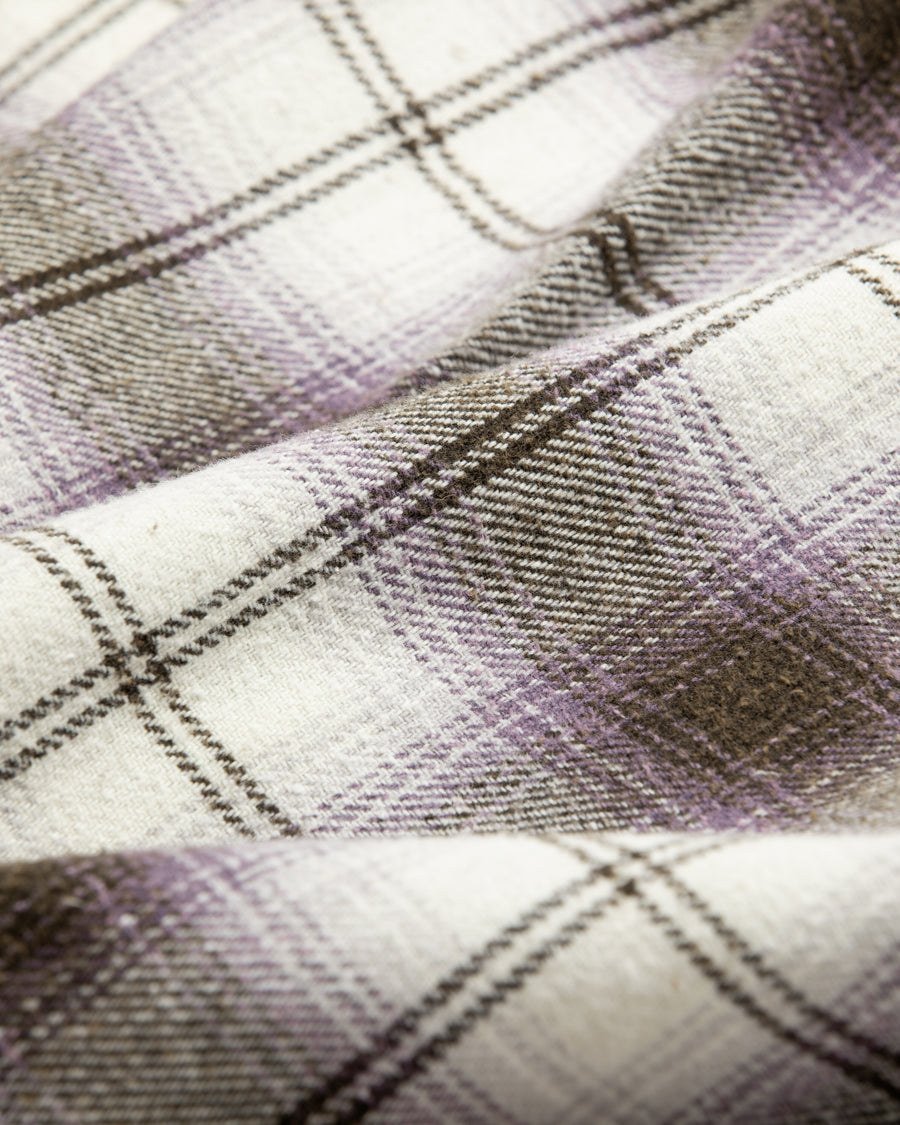 ANACHRONORMで以前リリースしていたリサイズシャツのシルエットをリファインした、ワイドシルエットシャツです。
随所に施された細かなステッチワークやダメージ加工にもご注目ください。
生地はリサイクルコットンとポリエステルを混紡したT/Cネップチェックで、起毛によるネップの風合いとメランジ染めの独特なムラ感が特徴です。
サスティナブルブリーチ加工とダメージ加工を施しており、環境に配慮しつつPURPLE×BLACKカラーで仕上げています。