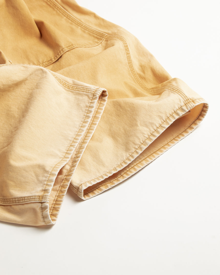 【 商品名：ダブルニーダックペインターパンツ 】

本製品は、レングスをやや長めに設定したイエローカラーのペインターパンツです。ウエスト部分にはナイロンオックス生地で切り替えを施し、ワーク感を抑えたデザインに仕上げています。生地には頒布の中でも最も薄手の11号帆布生地を使用しており、強度・耐久性に優れるだけでなく、着用を重ねるごとにアタリなどの経年変化を楽しめる素材です。また、水や薬品の使用量を抑えつつ生地の凹凸部分のアタリを強調し、同時に自然な脱色感を生み出す特殊エイジング加工を施しています。