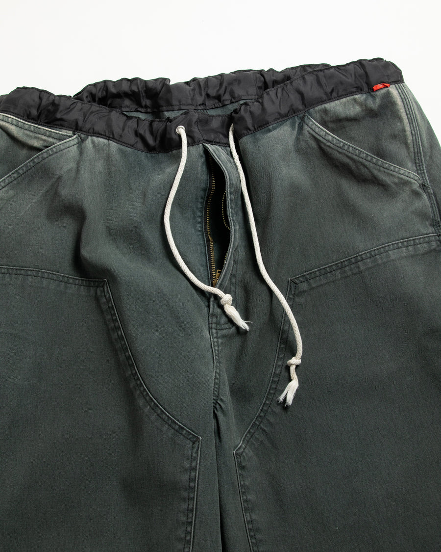【 商品名：ダブルニーダックペインターパンツ 】

本製品は、レングスをやや長めに設定したブラックカラーのペインターパンツです。ウエスト部分にはナイロンオックス生地で切り替えを施し、ワーク感を抑えた上品なデザインに仕上げています。生地には頒布の中でも最も薄手の11号帆布生地を採用しており、強度・耐久性に優れるとともに、着用を重ねるごとにアタリなどの経年変化を楽しめる素材です。また、水や薬品の使用量を抑えながら生地の凹凸部分のアタリを強調し、同時に自然な脱色感を加える特殊エイジング加工を施しています。
