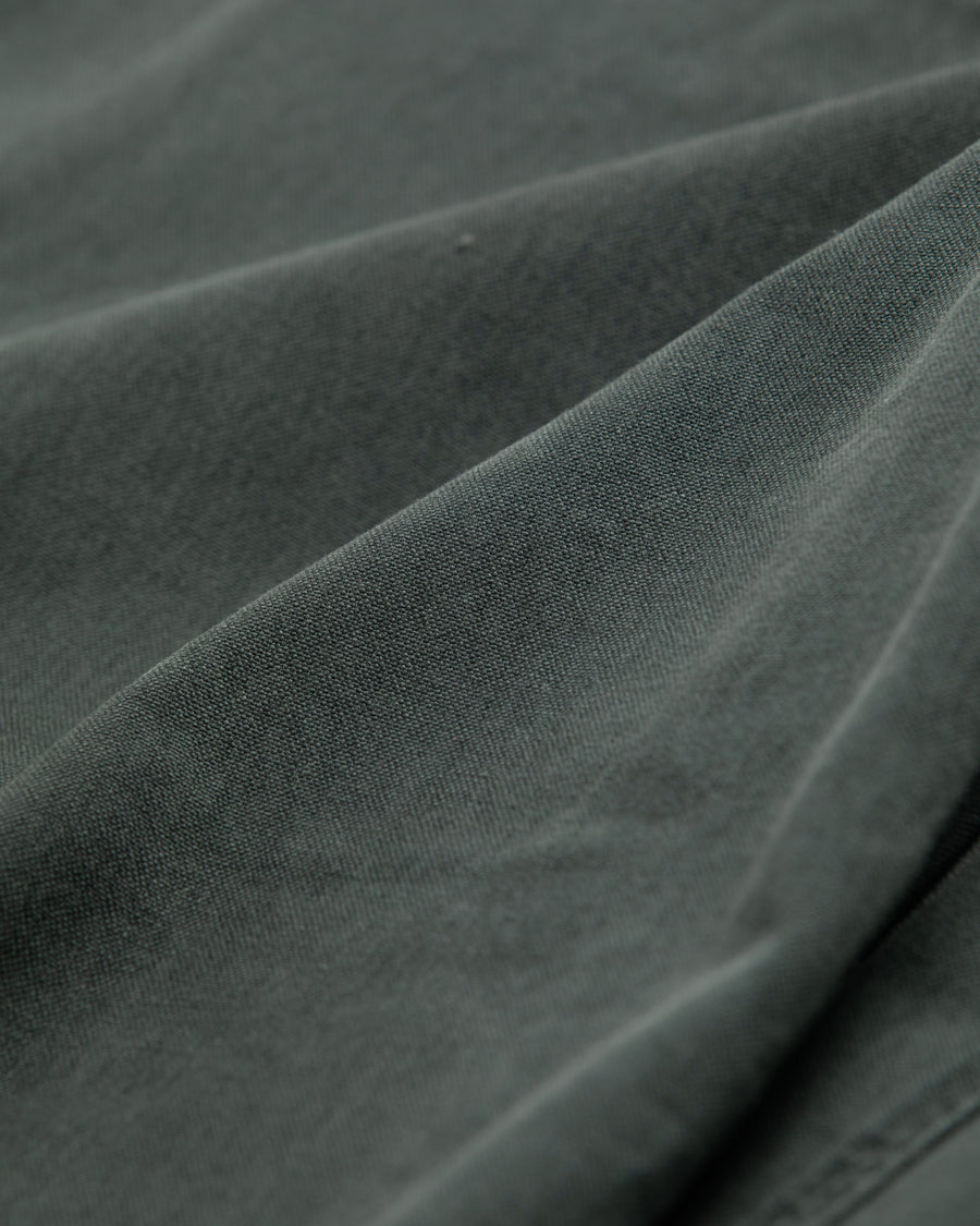 【 商品名：ダブルニーダックペインターパンツ 】

本製品は、レングスをやや長めに設定したブラックカラーのペインターパンツです。ウエスト部分にはナイロンオックス生地で切り替えを施し、ワーク感を抑えた上品なデザインに仕上げています。生地には頒布の中でも最も薄手の11号帆布生地を採用しており、強度・耐久性に優れるとともに、着用を重ねるごとにアタリなどの経年変化を楽しめる素材です。また、水や薬品の使用量を抑えながら生地の凹凸部分のアタリを強調し、同時に自然な脱色感を加える特殊エイジング加工を施しています。