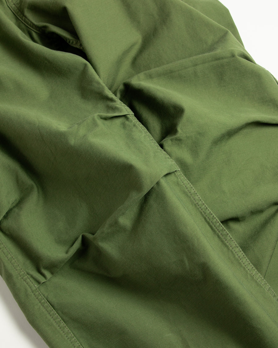 フラップポケットや膝のタック、裾のドローコードなど、ミリタリーディテールを随所に取り入れた1本。通常は内側に配置されるポケットをあえて外側に設けたカーゴポケットが印象的です。ムラ糸で織り上げたバックサテン生地は、独特のハリとコシを持ち、深みのあるオリーブカラーが魅力です。