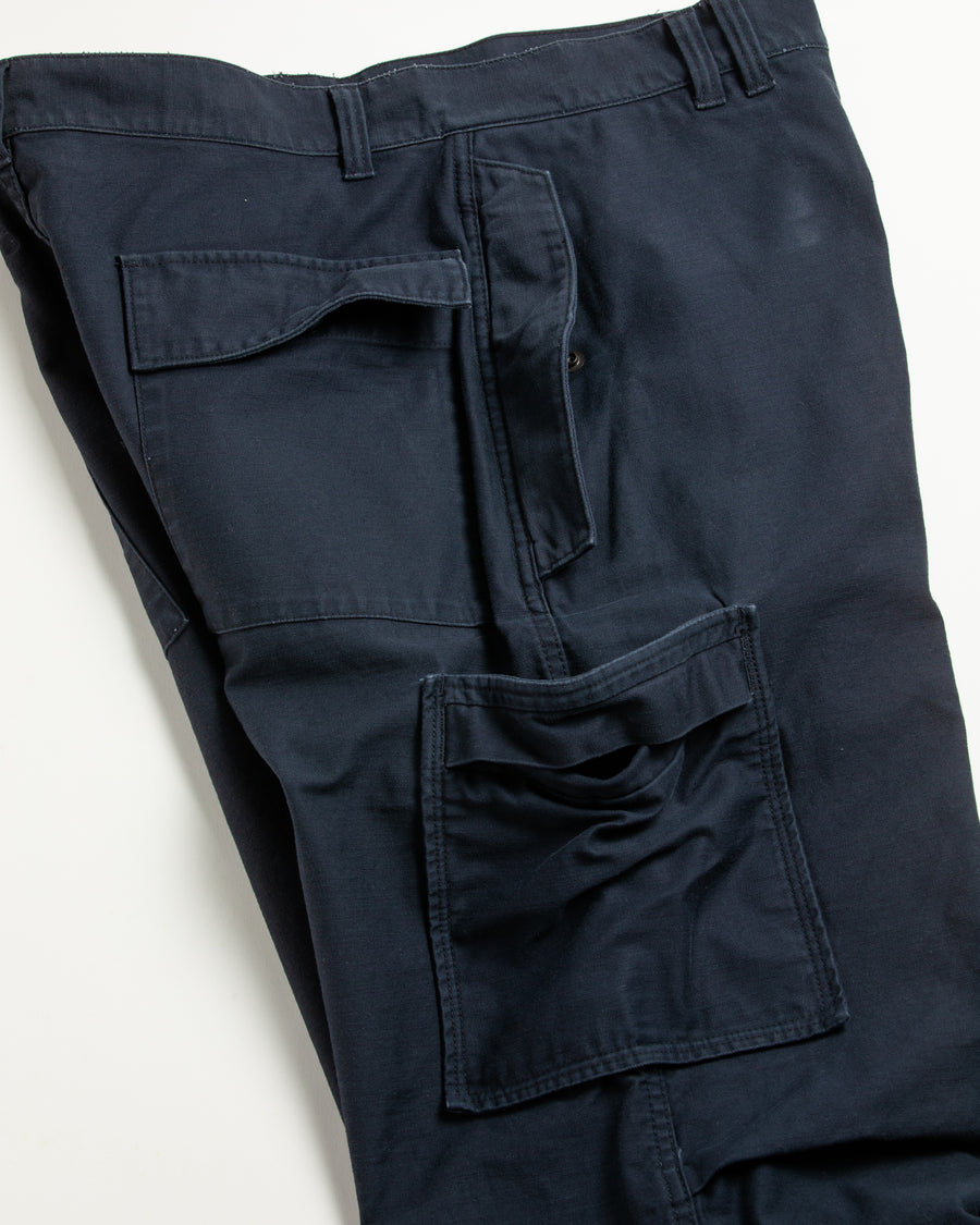 フラップポケットや膝のタック、裾のドローコードなど、ミリタリーディテールを随所に取り入れた1本。通常は内側に配置されるポケットをあえて外側に設けたカーゴポケットが印象的です。ムラ糸で織り上げたバックサテン生地は、独特のハリとコシを持ち、深みのあるネイビーカラーが魅力です。