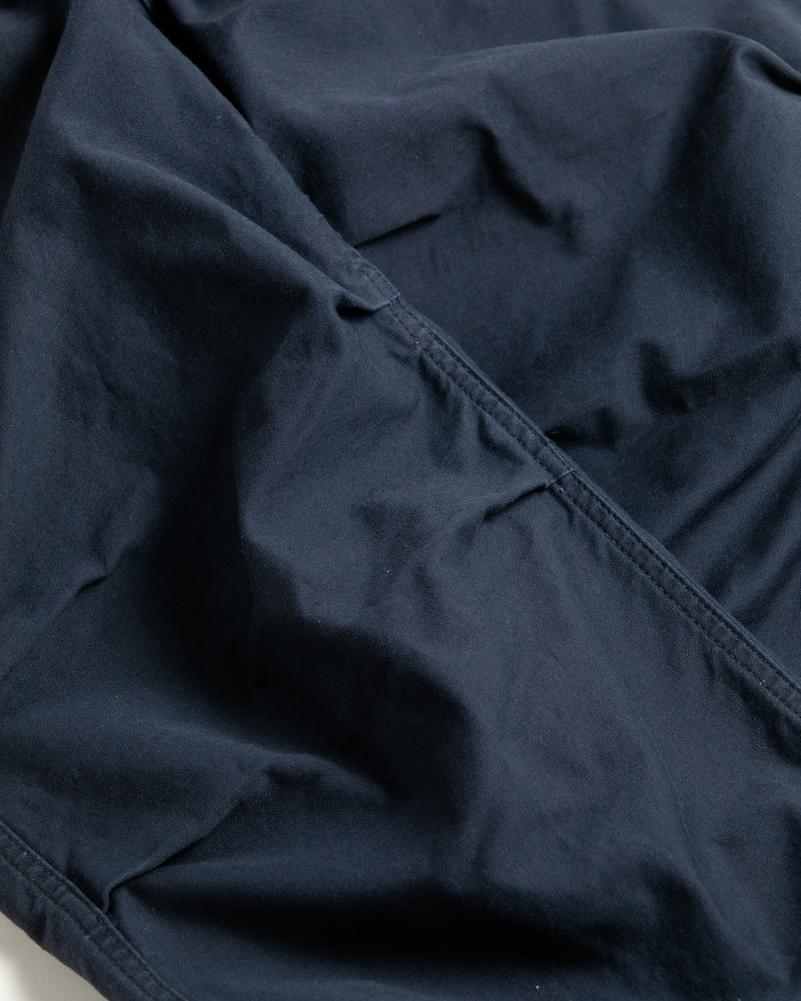 フラップポケットや膝のタック、裾のドローコードなど、ミリタリーディテールを随所に取り入れた1本。通常は内側に配置されるポケットをあえて外側に設けたカーゴポケットが印象的です。ムラ糸で織り上げたバックサテン生地は、独特のハリとコシを持ち、深みのあるネイビーカラーが魅力です。