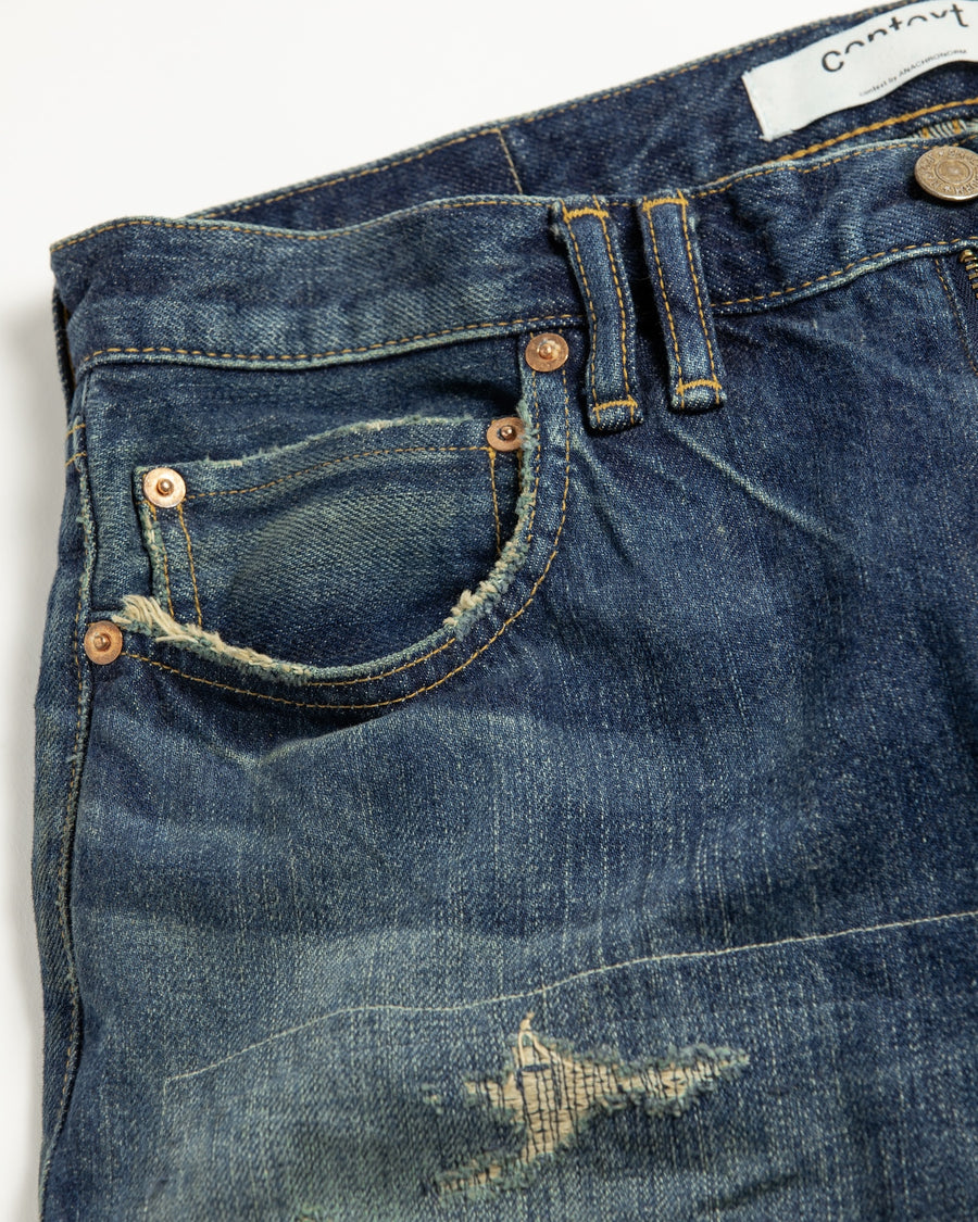 12.5ozデニムを使用したテーパードシルエット。
濃色エイジングとブリーチを組み合わせたハードダメージ加工。
複数の当て布でパッチワークリメイクを施した存在感ある一本です。
A tapered silhouette crafted from 12.5oz denim.
Features heavy damage with dark aging and bleach treatments.
Finished with patchwork-style remake details using multiple fabric patches.