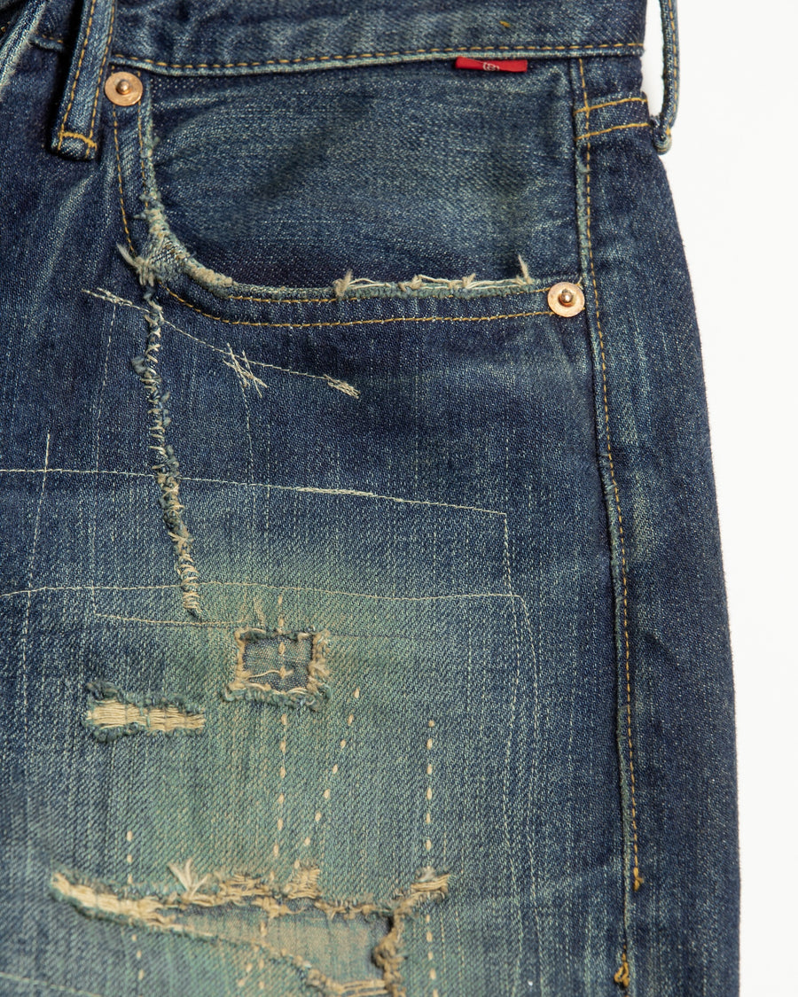 12.5ozデニムを使用したテーパードシルエット。
濃色エイジングとブリーチを組み合わせたハードダメージ加工。
複数の当て布でパッチワークリメイクを施した存在感ある一本です。
A tapered silhouette crafted from 12.5oz denim.
Features heavy damage with dark aging and bleach treatments.
Finished with patchwork-style remake details using multiple fabric patches.