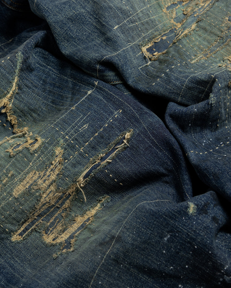 12.5ozデニムを使用したテーパードシルエット。
濃色エイジングとブリーチを組み合わせたハードダメージ加工。
複数の当て布でパッチワークリメイクを施した存在感ある一本です。
A tapered silhouette crafted from 12.5oz denim.
Features heavy damage with dark aging and bleach treatments.
Finished with patchwork-style remake details using multiple fabric patches.