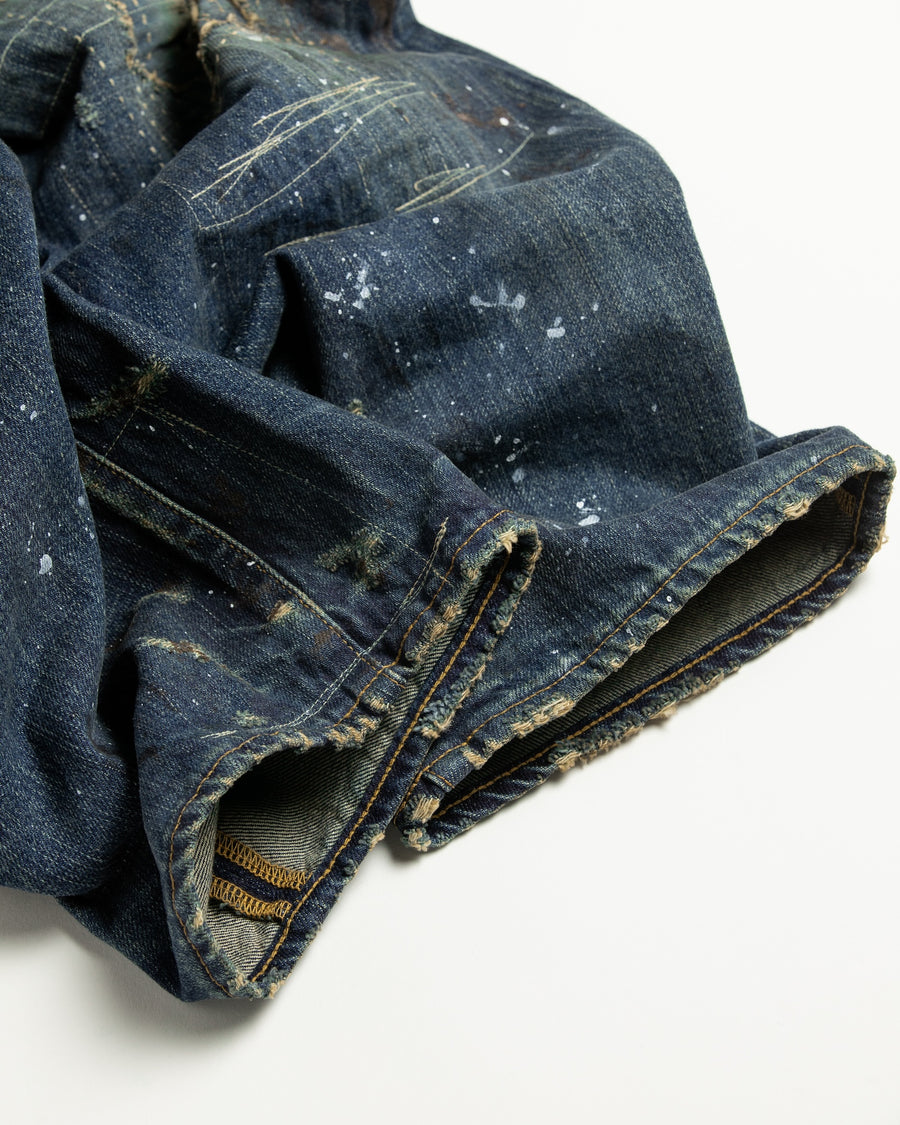 12.5ozデニムを使用したテーパードシルエット。
濃色エイジングとブリーチを組み合わせたハードダメージ加工。
複数の当て布でパッチワークリメイクを施した存在感ある一本です。
A tapered silhouette crafted from 12.5oz denim.
Features heavy damage with dark aging and bleach treatments.
Finished with patchwork-style remake details using multiple fabric patches.