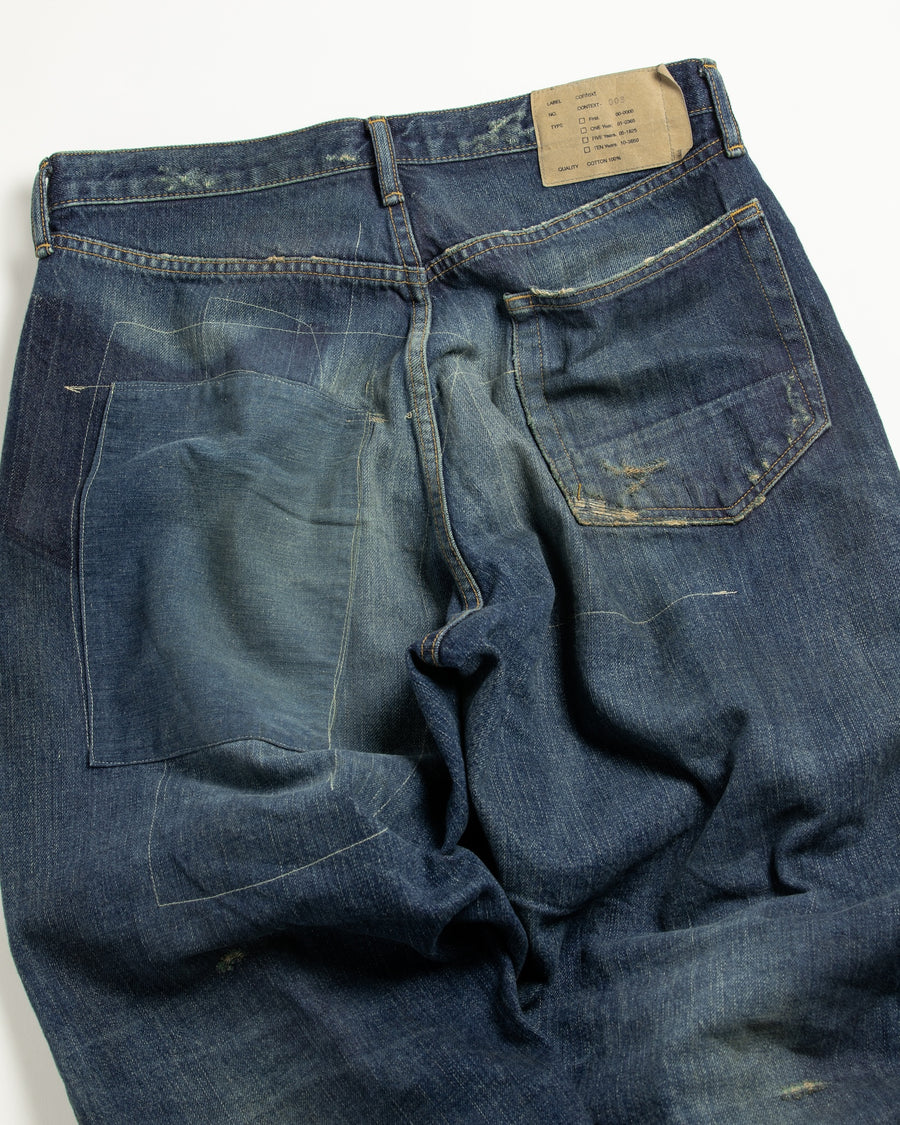 12.5ozデニムを使用したテーパードシルエット。
濃色エイジングとブリーチを組み合わせたハードダメージ加工。
複数の当て布でパッチワークリメイクを施した存在感ある一本です。
A tapered silhouette crafted from 12.5oz denim.
Features heavy damage with dark aging and bleach treatments.
Finished with patchwork-style remake details using multiple fabric patches.