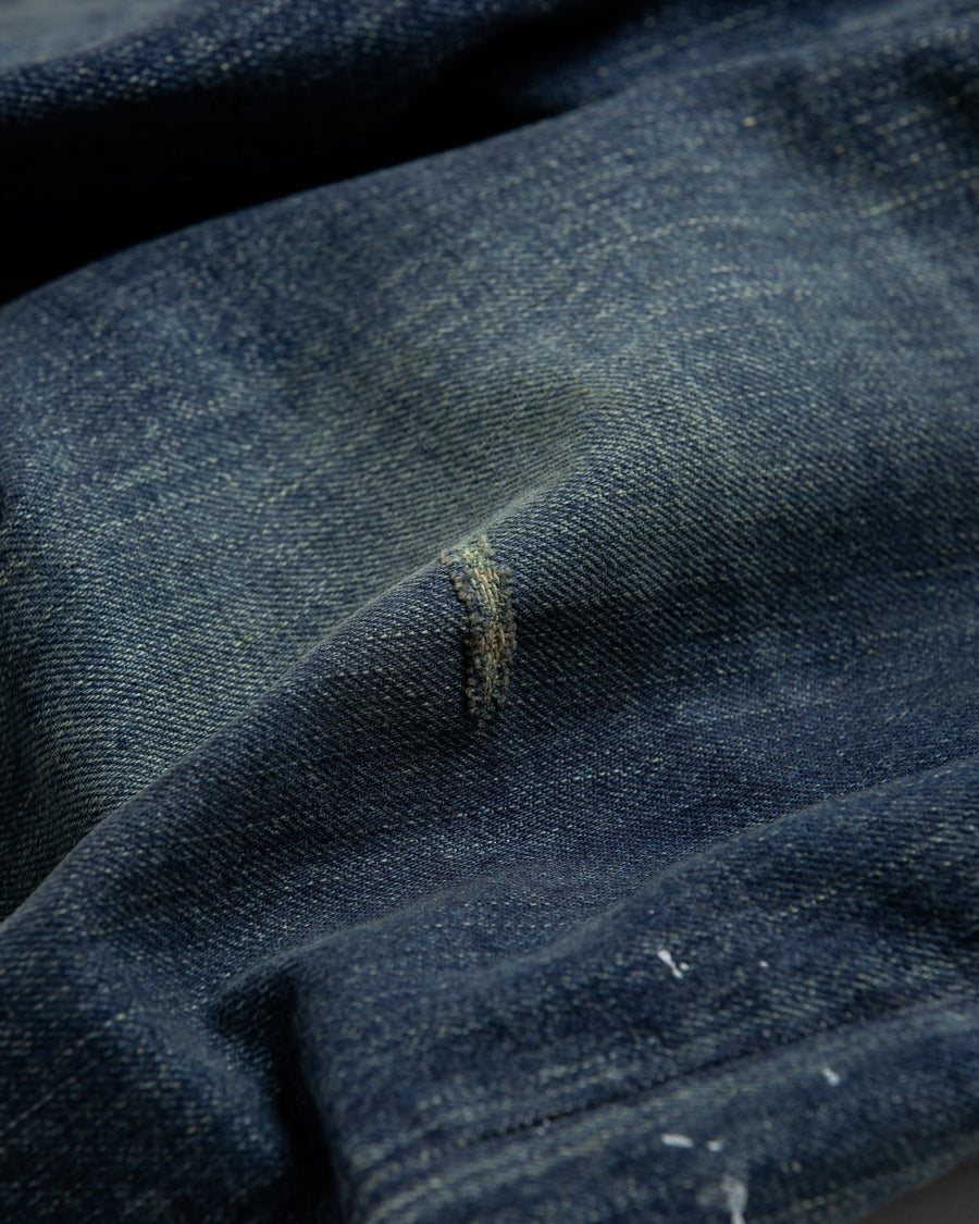 12.5ozデニムを使用したテーパードシルエット。
濃色エイジングとブリーチを組み合わせたハードダメージ加工。
複数の当て布でパッチワークリメイクを施した存在感ある一本です。
A tapered silhouette crafted from 12.5oz denim.
Features heavy damage with dark aging and bleach treatments.
Finished with patchwork-style remake details using multiple fabric patches.