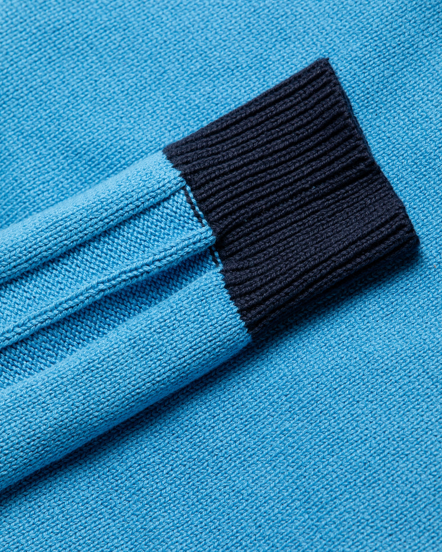 コットンニットを使用したドライバーズニット。
太番手の強撚糸による特殊な天竺編みで、適度なハリと風合いを持たせています。
ゆとりのある身幅ながら、アウターのインナーとしても使いやすいバランスの取れたシルエットに仕上げました。コットン素材のためホームクリーニングも可能です。
カラーは鮮やかなスカイブルー。
