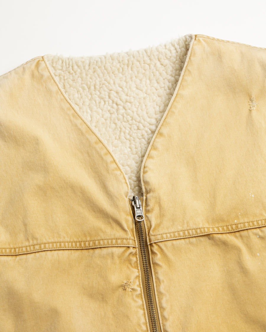 リバーシブルで着用が可能なダック×ボアのワークベスト。
カラーはイエロー。
某ワークブランドよりも生地の重量が軽量なのでストレスの少ないライトな着用感も魅力的です。

■表地 : 11号帆布生地
頒布の中で最も薄手の11号を使用しており、強度・耐久性に優れ、着用を重ねるごとにアタリなどの経年変化を感じられる素材です。
■裏地 : シープボア
毛足がありながら、ざらつきが少ないソフトなボア生地です。

■加工 : 特殊エイジング加工/サンフェードダメージ加工
水や薬品の使用量を軽減させながら生地の凹凸部分のアタリを強調させ、同時に脱色させる特殊加工です。
さらにダメージ加工を施しております。