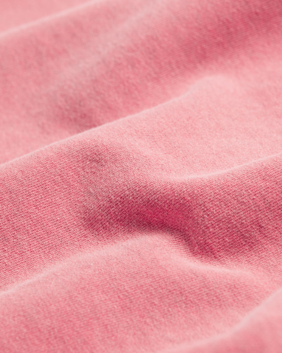 フードをカットオフした薄い赤色のスウェットパーカー。
染色と加工によって日焼けし褪せたようなリアルな表情を出しています。