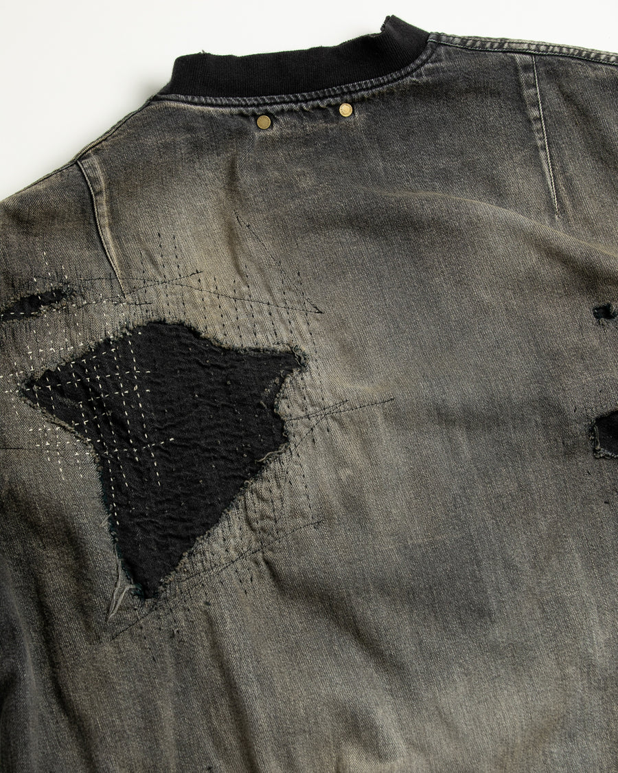 ブランドを象徴するデニムで構築した、MA-1ベースのリメイクジャケット。ライトオンスデニムを二重縫製することで、柔らかさと程よい肉感を実現しています。8ozムラ糸デニムがもつ粗野な表情が、強いヴィンテージ感を演出。全体にエイジングを施したうえで、ハードダメージ加工で仕上げた一着。さらに手作業による多様なステッチ補修を重ね、唯一無二の表情に仕上げています。Crafted from the brand’s signature denim, this MA-1–inspired jacket features a refined and faithful silhouette.Lightweight denim with double stitching creates a soft feel and balanced structure.The 8oz slub denim offers a rugged character that enhances its vintage appeal.An overall aging treatment is followed by a hard damage finis
