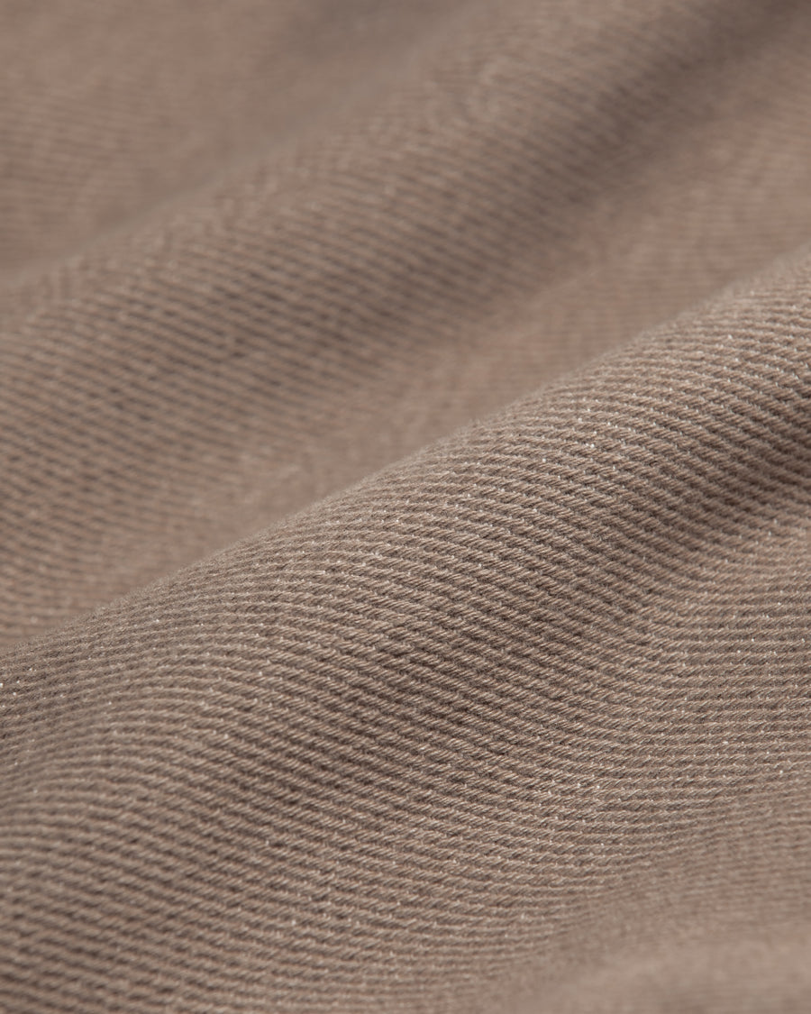 メキシカンパーカーの特徴や印象を忠実に再現しつつ、寸法を調整してシルエットを整えた一着です。
柔らかな甘織りデニムを使用し、快適な着心地に仕上げています。
太畝ツイルデニムは弱スラブ糸で織り上げたふっくらとした質感と自然なストレッチ性が特徴で、ベージュカラーが上品な印象を与えます。