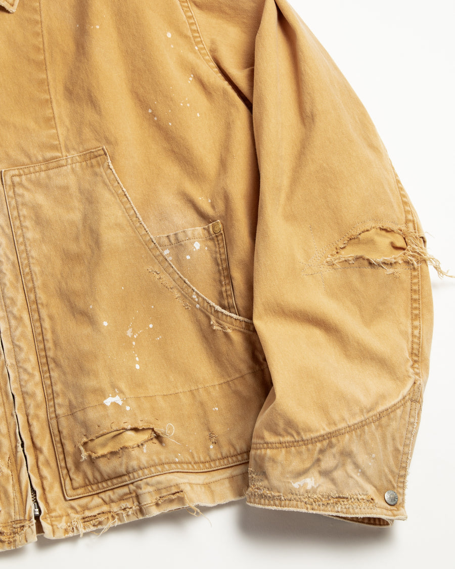 【 商品名：リメイクデトロイトダックジャケット 】

本製品は、ゆとりのある身幅とややクロップド丈に設計されたイエローカラーのジャケットで、インナーアイテムとのレイヤードを楽しめるバランスの良いシルエットが特徴です。生地には頒布の中でも最も薄手の11号帆布生地を使用しており、強度・耐久性に優れるとともに、着用を重ねるごとにアタリなどの経年変化を味わえる素材です。さらに、水や薬品の使用量を抑えながら生地の凹凸部分のアタリを強調し、同時に自然な脱色感を生み出す特殊エイジング加工を施し、加えてサンフェードによるダメージ加工も行うことで、より深みのある表情に仕上げています。