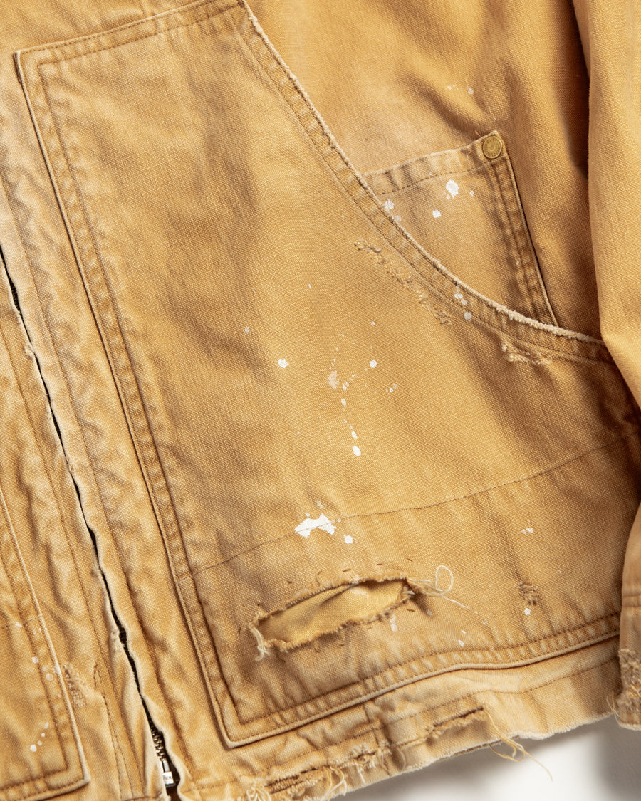 【 商品名：リメイクデトロイトダックジャケット 】

本製品は、ゆとりのある身幅とややクロップド丈に設計されたイエローカラーのジャケットで、インナーアイテムとのレイヤードを楽しめるバランスの良いシルエットが特徴です。生地には頒布の中でも最も薄手の11号帆布生地を使用しており、強度・耐久性に優れるとともに、着用を重ねるごとにアタリなどの経年変化を味わえる素材です。さらに、水や薬品の使用量を抑えながら生地の凹凸部分のアタリを強調し、同時に自然な脱色感を生み出す特殊エイジング加工を施し、加えてサンフェードによるダメージ加工も行うことで、より深みのある表情に仕上げています。