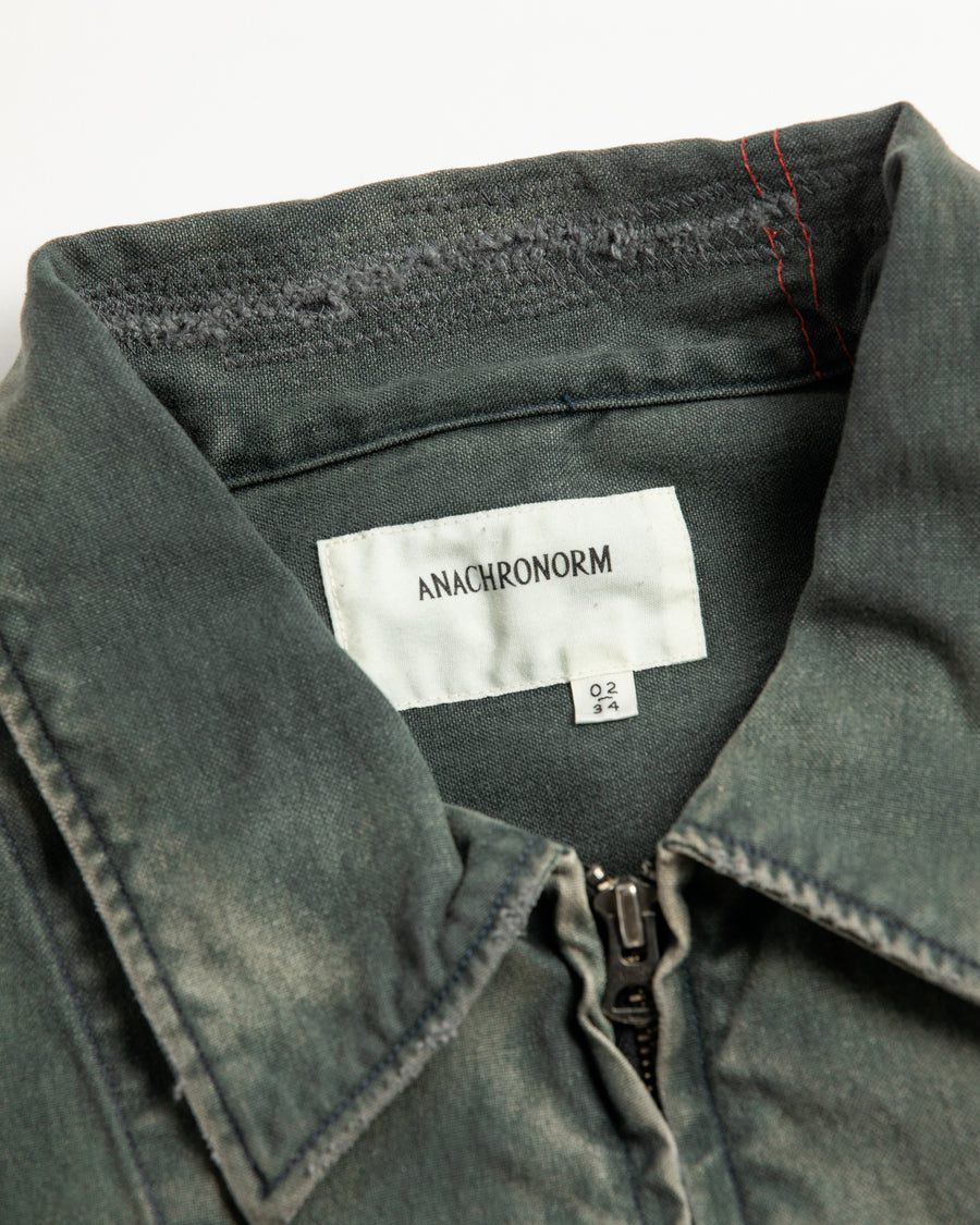 【 商品名：リメイクデトロイトダックジャケット 】

本製品は、ゆとりのある身幅とややクロップド丈に設計されたブラックカラーのジャケットで、インナーアイテムとのレイヤードを楽しめるバランスの良いシルエットが特徴です。生地には頒布の中でも最も薄手の11号帆布生地を採用しており、強度・耐久性に優れ、着用を重ねるごとにアタリなどの経年変化を味わえる素材です。さらに、水や薬品の使用量を抑えながら生地の凹凸部分のアタリを強調し、同時に自然な脱色感を生み出す特殊エイジング加工を施し、加えてサンフェードによるダメージ加工を加えることで、より奥行きのある表情に仕上げています。