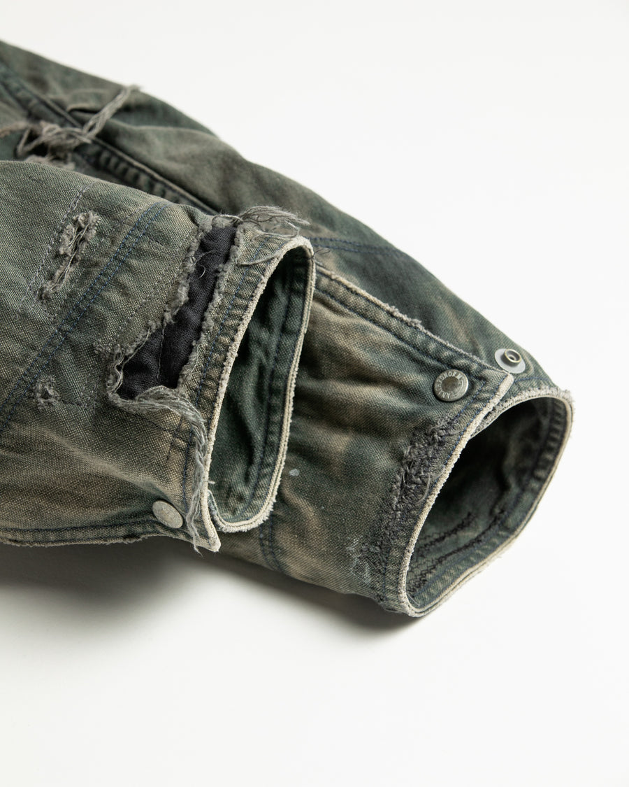 【 商品名：リメイクデトロイトダックジャケット 】

本製品は、ゆとりのある身幅とややクロップド丈に設計されたブラックカラーのジャケットで、インナーアイテムとのレイヤードを楽しめるバランスの良いシルエットが特徴です。生地には頒布の中でも最も薄手の11号帆布生地を採用しており、強度・耐久性に優れ、着用を重ねるごとにアタリなどの経年変化を味わえる素材です。さらに、水や薬品の使用量を抑えながら生地の凹凸部分のアタリを強調し、同時に自然な脱色感を生み出す特殊エイジング加工を施し、加えてサンフェードによるダメージ加工を加えることで、より奥行きのある表情に仕上げています。