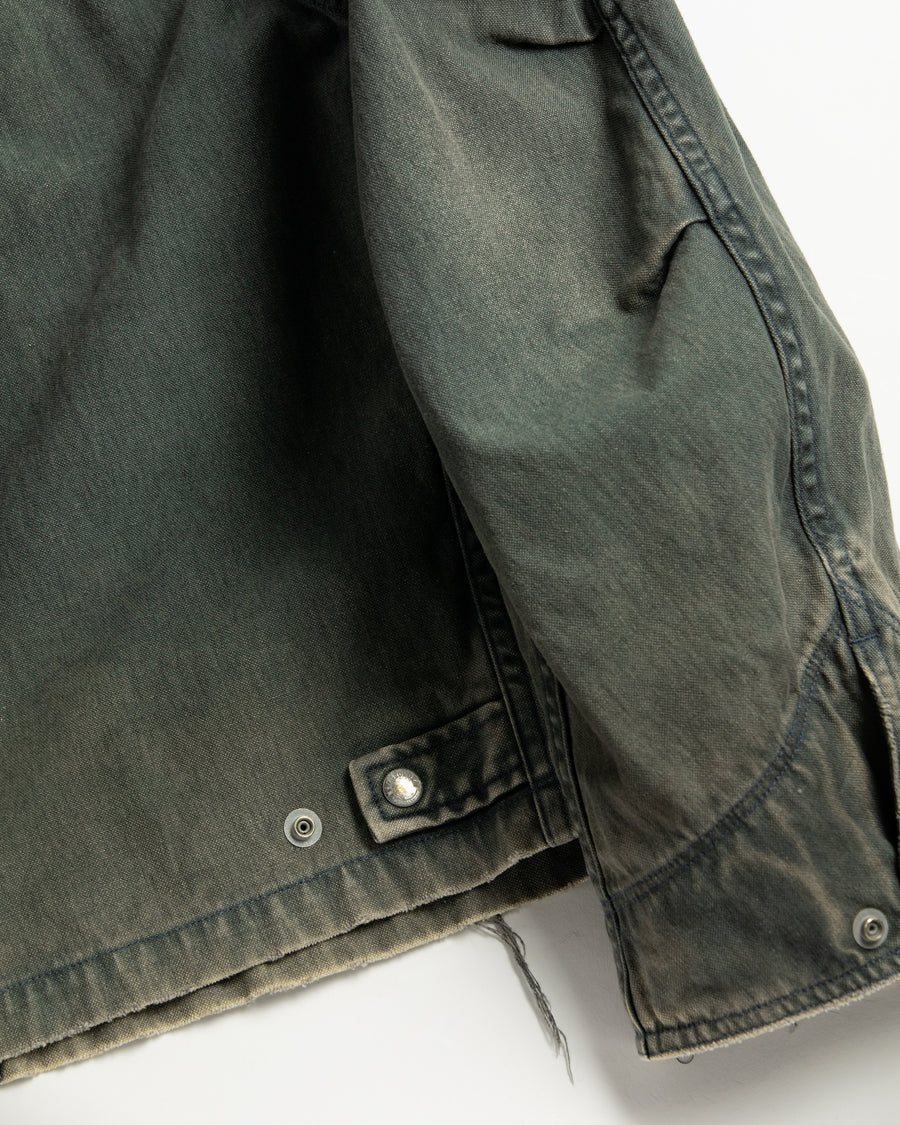 【 商品名：リメイクデトロイトダックジャケット 】

本製品は、ゆとりのある身幅とややクロップド丈に設計されたブラックカラーのジャケットで、インナーアイテムとのレイヤードを楽しめるバランスの良いシルエットが特徴です。生地には頒布の中でも最も薄手の11号帆布生地を採用しており、強度・耐久性に優れ、着用を重ねるごとにアタリなどの経年変化を味わえる素材です。さらに、水や薬品の使用量を抑えながら生地の凹凸部分のアタリを強調し、同時に自然な脱色感を生み出す特殊エイジング加工を施し、加えてサンフェードによるダメージ加工を加えることで、より奥行きのある表情に仕上げています。