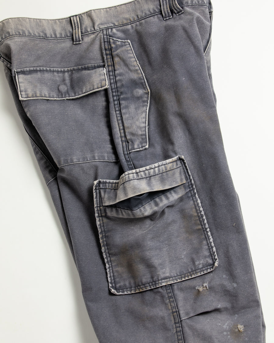 フラップポケットや膝のタック、裾のドローコードなど、ミリタリーのディテールをふんだんに取り入れた一本。内側に配置されることの多いポケットをあえて外側に設けたカーゴポケットが特徴です。ムラ糸で織り上げたバックサテン生地は、ハリとコシのある質感が魅力。さらに、水や薬品の使用を抑えながら生地の凹凸を際立たせる特殊エイジング加工を施し、深みのあるネイビーカラーに仕上げています。