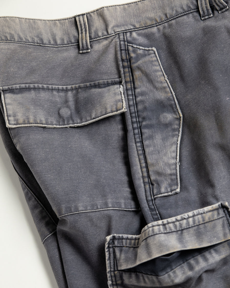 フラップポケットや膝のタック、裾のドローコードなど、ミリタリーのディテールをふんだんに取り入れた一本。内側に配置されることの多いポケットをあえて外側に設けたカーゴポケットが特徴です。ムラ糸で織り上げたバックサテン生地は、ハリとコシのある質感が魅力。さらに、水や薬品の使用を抑えながら生地の凹凸を際立たせる特殊エイジング加工を施し、深みのあるネイビーカラーに仕上げています。