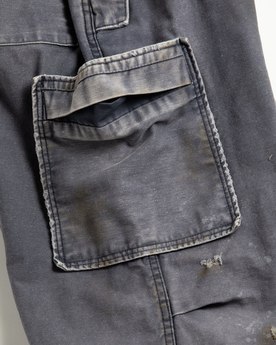 フラップポケットや膝のタック、裾のドローコードなど、ミリタリーのディテールをふんだんに取り入れた一本。内側に配置されることの多いポケットをあえて外側に設けたカーゴポケットが特徴です。ムラ糸で織り上げたバックサテン生地は、ハリとコシのある質感が魅力。さらに、水や薬品の使用を抑えながら生地の凹凸を際立たせる特殊エイジング加工を施し、深みのあるネイビーカラーに仕上げています。