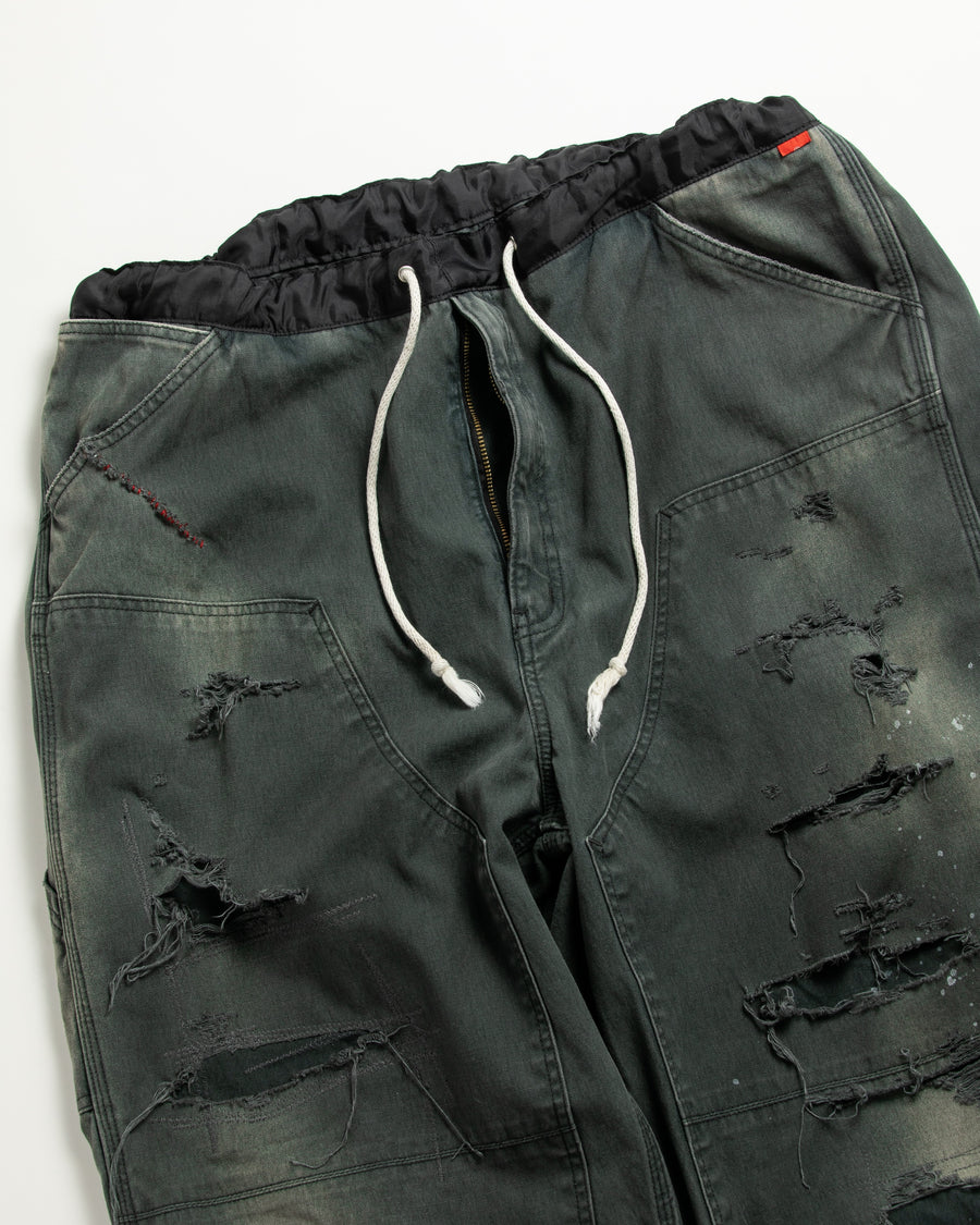 【 商品名：リメイクダブルニーダックペインターパンツ 】

本製品は、レングスをやや長めに設定したブラックカラーのペインターパンツです。ウエスト部分にはナイロンオックス生地で切り替えを施し、ワーク感を抑えつつバランスの良いデザインに仕上げています。生地には頒布の中でも最も薄手の11号帆布生地を使用しており、強度・耐久性に優れるだけでなく、着用を重ねるごとにアタリなどの経年変化を楽しめる素材です。また、水や薬品の使用量を抑えながら生地の凹凸部分のアタリを強調し、同時に自然な脱色感を与える特殊エイジング加工に加え、サンフェードによるダメージ加工も施すことで、より味わい深い表情に仕上げています。