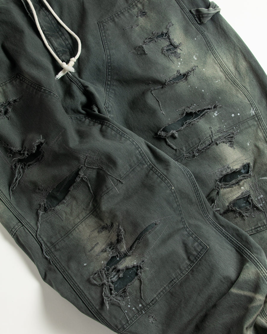 【 商品名：リメイクダブルニーダックペインターパンツ 】

本製品は、レングスをやや長めに設定したブラックカラーのペインターパンツです。ウエスト部分にはナイロンオックス生地で切り替えを施し、ワーク感を抑えつつバランスの良いデザインに仕上げています。生地には頒布の中でも最も薄手の11号帆布生地を使用しており、強度・耐久性に優れるだけでなく、着用を重ねるごとにアタリなどの経年変化を楽しめる素材です。また、水や薬品の使用量を抑えながら生地の凹凸部分のアタリを強調し、同時に自然な脱色感を与える特殊エイジング加工に加え、サンフェードによるダメージ加工も施すことで、より味わい深い表情に仕上げています。