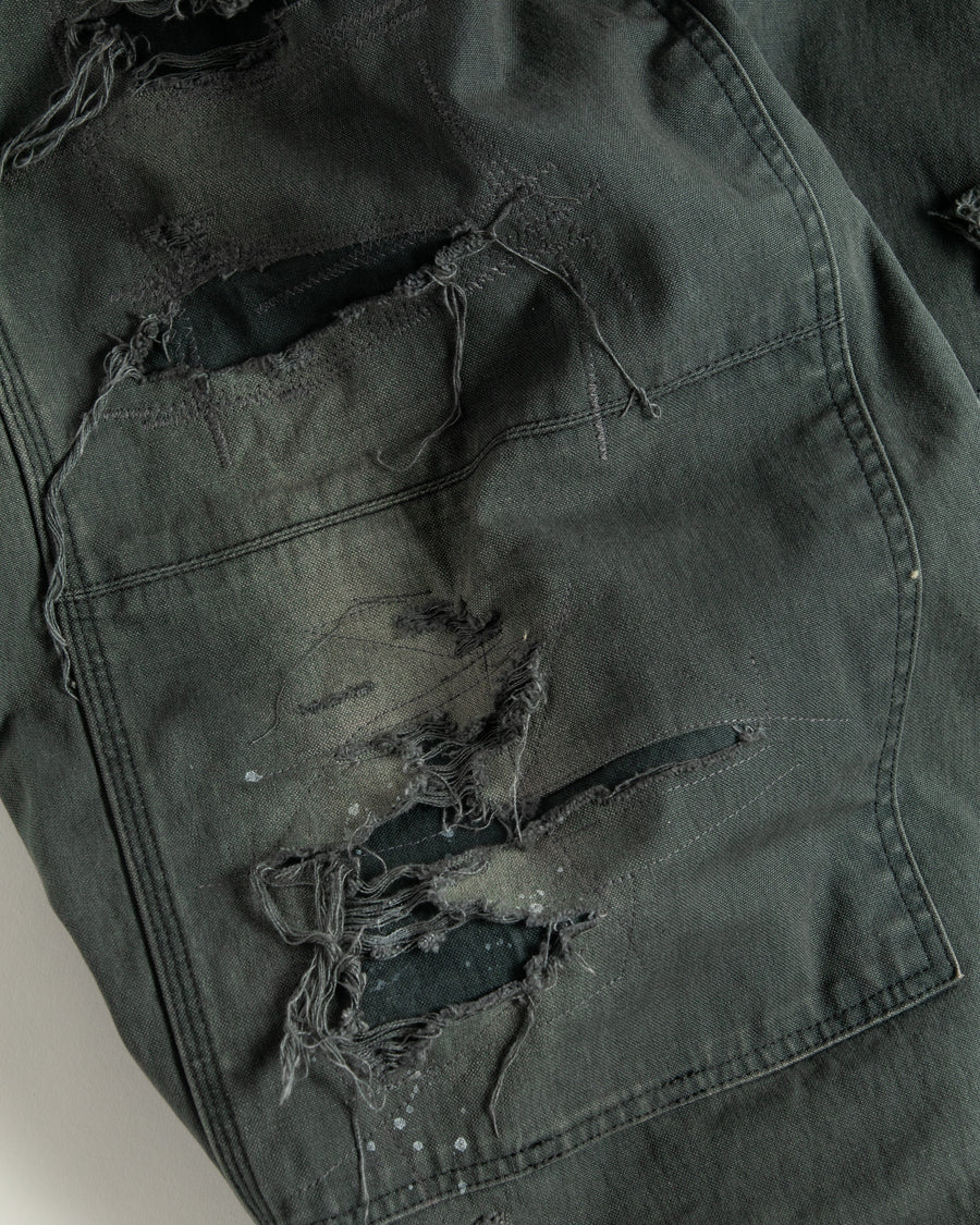 【 商品名：リメイクダブルニーダックペインターパンツ 】

本製品は、レングスをやや長めに設定したブラックカラーのペインターパンツです。ウエスト部分にはナイロンオックス生地で切り替えを施し、ワーク感を抑えつつバランスの良いデザインに仕上げています。生地には頒布の中でも最も薄手の11号帆布生地を使用しており、強度・耐久性に優れるだけでなく、着用を重ねるごとにアタリなどの経年変化を楽しめる素材です。また、水や薬品の使用量を抑えながら生地の凹凸部分のアタリを強調し、同時に自然な脱色感を与える特殊エイジング加工に加え、サンフェードによるダメージ加工も施すことで、より味わい深い表情に仕上げています。