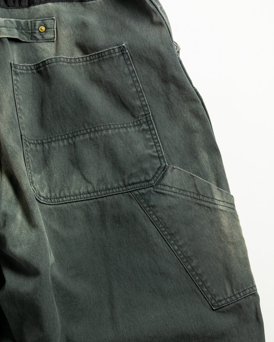 【 商品名：リメイクダブルニーダックペインターパンツ 】

本製品は、レングスをやや長めに設定したブラックカラーのペインターパンツです。ウエスト部分にはナイロンオックス生地で切り替えを施し、ワーク感を抑えつつバランスの良いデザインに仕上げています。生地には頒布の中でも最も薄手の11号帆布生地を使用しており、強度・耐久性に優れるだけでなく、着用を重ねるごとにアタリなどの経年変化を楽しめる素材です。また、水や薬品の使用量を抑えながら生地の凹凸部分のアタリを強調し、同時に自然な脱色感を与える特殊エイジング加工に加え、サンフェードによるダメージ加工も施すことで、より味わい深い表情に仕上げています。