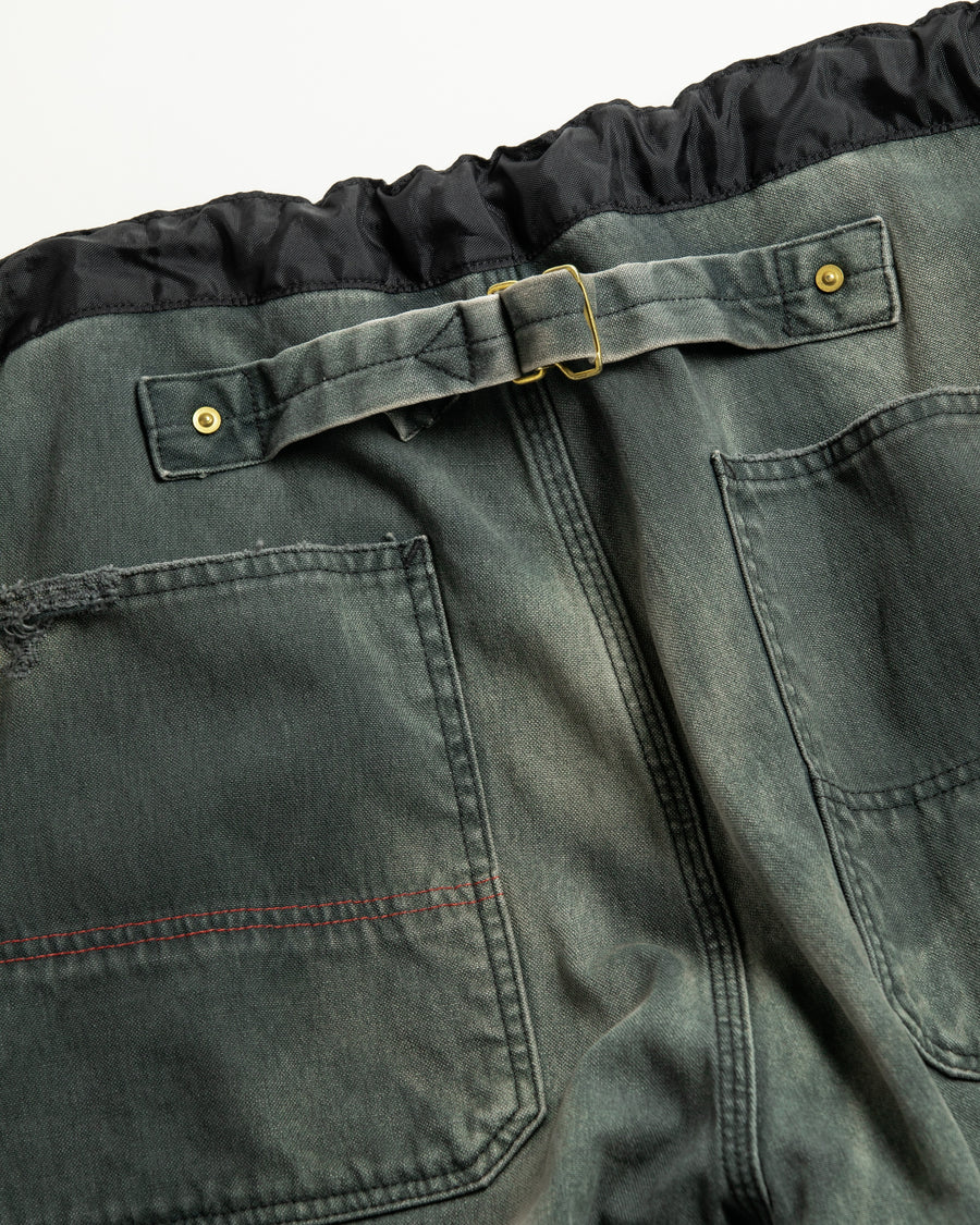 【 商品名：リメイクダブルニーダックペインターパンツ 】

本製品は、レングスをやや長めに設定したブラックカラーのペインターパンツです。ウエスト部分にはナイロンオックス生地で切り替えを施し、ワーク感を抑えつつバランスの良いデザインに仕上げています。生地には頒布の中でも最も薄手の11号帆布生地を使用しており、強度・耐久性に優れるだけでなく、着用を重ねるごとにアタリなどの経年変化を楽しめる素材です。また、水や薬品の使用量を抑えながら生地の凹凸部分のアタリを強調し、同時に自然な脱色感を与える特殊エイジング加工に加え、サンフェードによるダメージ加工も施すことで、より味わい深い表情に仕上げています。