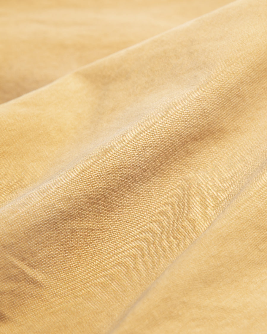 【 商品名：リメイクダブルニーダックペインターパンツ 】

本製品は、レングスをやや長めに設定したイエローカラーのペインターパンツです。ウエスト部分にはナイロンオックス生地で切り替えを施し、ワーク感を抑えたバランスの良いデザインに仕上げています。生地には頒布の中でも最も薄手の11号帆布生地を使用しており、強度・耐久性に優れるだけでなく、着用を重ねるごとにアタリなどの経年変化を味わえる素材です。また、水や薬品の使用量を抑えながら生地の凹凸部分のアタリを強調し、同時に自然な脱色感を与える特殊エイジング加工に加え、サンフェードによるダメージ加工も施すことで、より深みのある表情に仕上げています。