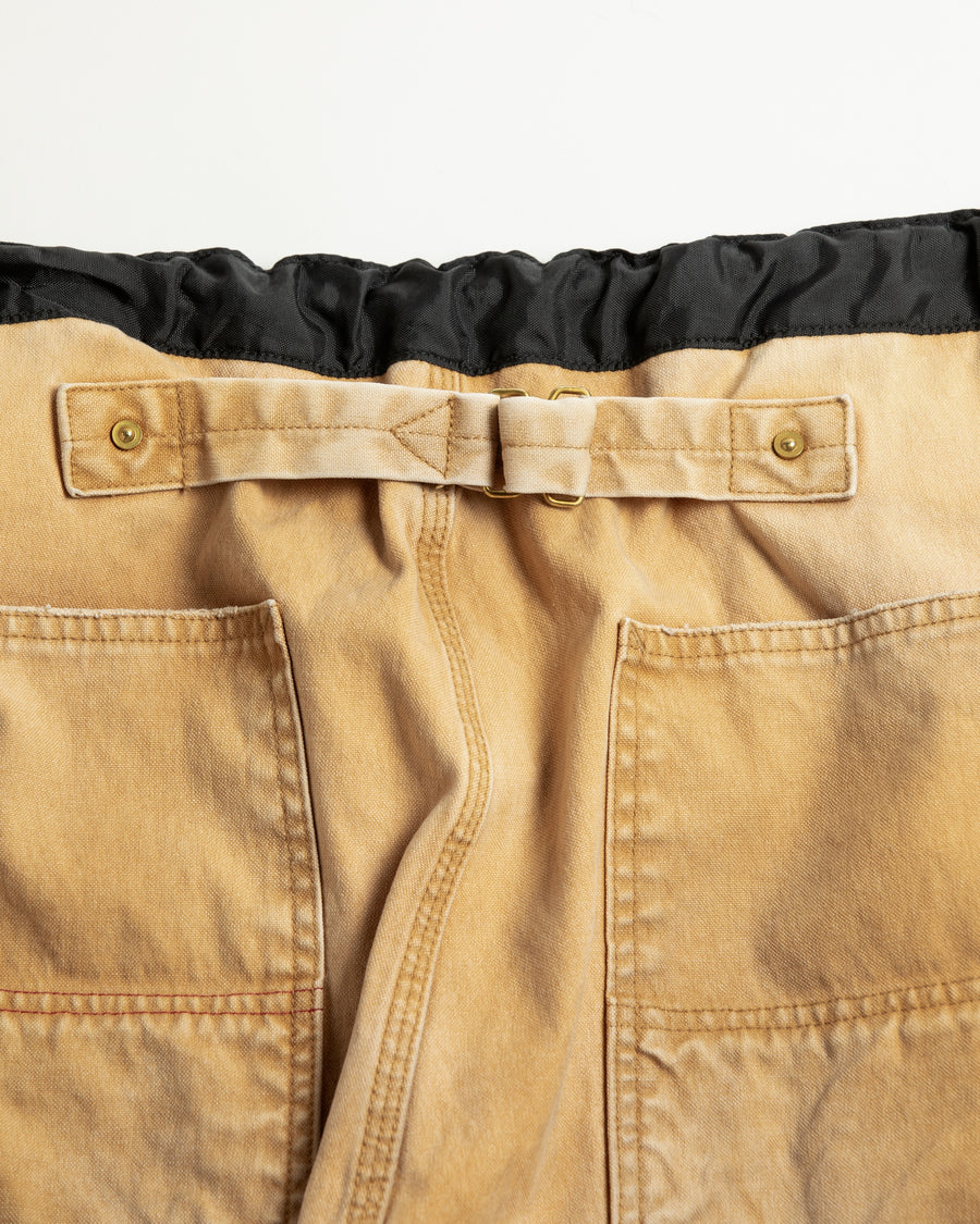 【 商品名：リメイクダブルニーダックペインターパンツ 】

本製品は、レングスをやや長めに設定したイエローカラーのペインターパンツです。ウエスト部分にはナイロンオックス生地で切り替えを施し、ワーク感を抑えたバランスの良いデザインに仕上げています。生地には頒布の中でも最も薄手の11号帆布生地を使用しており、強度・耐久性に優れるだけでなく、着用を重ねるごとにアタリなどの経年変化を味わえる素材です。また、水や薬品の使用量を抑えながら生地の凹凸部分のアタリを強調し、同時に自然な脱色感を与える特殊エイジング加工に加え、サンフェードによるダメージ加工も施すことで、より深みのある表情に仕上げています。
