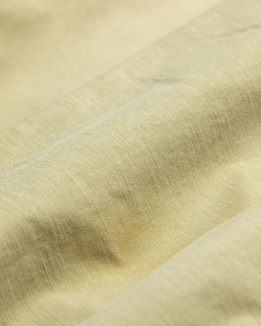 フラップポケットや膝のタック、裾のドローコードなど、ミリタリーのディテールをふんだんに取り入れた一本。内側に配置されることの多いポケットをあえて外側に設けたカーゴポケットが特徴です。ムラ糸で織り上げたバックサテン生地は、ハリとコシのある質感が魅力。さらに、水や薬品の使用を抑えながら生地の凹凸を際立たせる特殊エイジング加工を施し、深みのあるオリーブカラーに仕上げています。