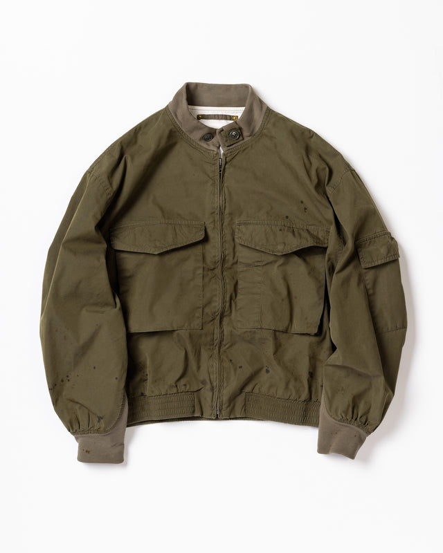 1950年代の希少なフライトジャケットをベースにシルエットを調整し、特徴的なディテールを再現したオリーブカラーのジャケット。
生地にはM1951 ARCTIC OVER PANTSを解析して再現したリプロ素材を使用し、光沢感のあるブライトナイロンを採用。
毛焼きをせずタンブラー仕上げでヴィンテージ感を演出しています。