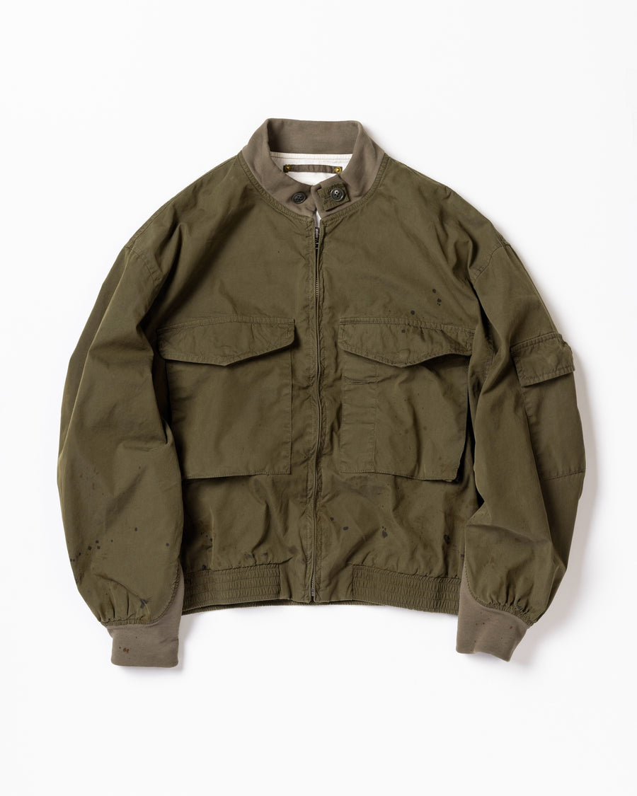 1950年代の希少なフライトジャケットをベースにシルエットを調整し、特徴的なディテールを再現したオリーブカラーのジャケット。
生地にはM1951 ARCTIC OVER PANTSを解析して再現したリプロ素材を使用し、光沢感のあるブライトナイロンを採用。
毛焼きをせずタンブラー仕上げでヴィンテージ感を演出しています。