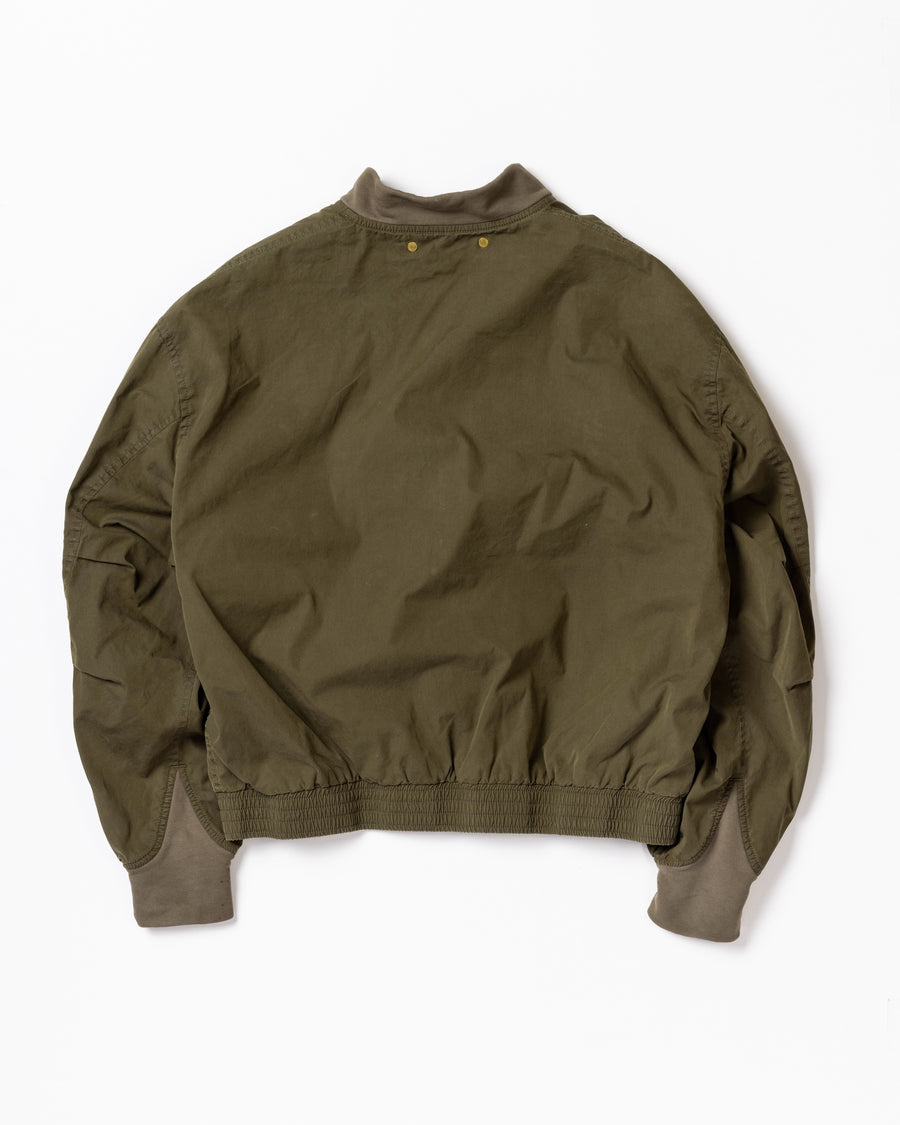 1950年代の希少なフライトジャケットをベースにシルエットを調整し、特徴的なディテールを再現したオリーブカラーのジャケット。
生地にはM1951 ARCTIC OVER PANTSを解析して再現したリプロ素材を使用し、光沢感のあるブライトナイロンを採用。
毛焼きをせずタンブラー仕上げでヴィンテージ感を演出しています。