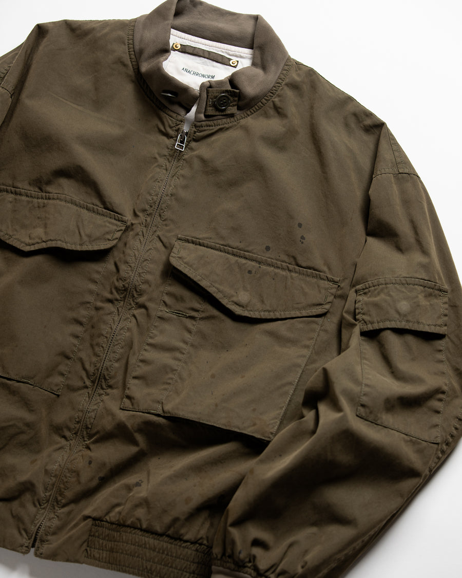 1950年代の希少なフライトジャケットをベースにシルエットを調整し、特徴的なディテールを再現したオリーブカラーのジャケット。
生地にはM1951 ARCTIC OVER PANTSを解析して再現したリプロ素材を使用し、光沢感のあるブライトナイロンを採用。
毛焼きをせずタンブラー仕上げでヴィンテージ感を演出しています。