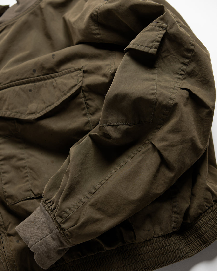 1950年代の希少なフライトジャケットをベースにシルエットを調整し、特徴的なディテールを再現したオリーブカラーのジャケット。
生地にはM1951 ARCTIC OVER PANTSを解析して再現したリプロ素材を使用し、光沢感のあるブライトナイロンを採用。
毛焼きをせずタンブラー仕上げでヴィンテージ感を演出しています。
