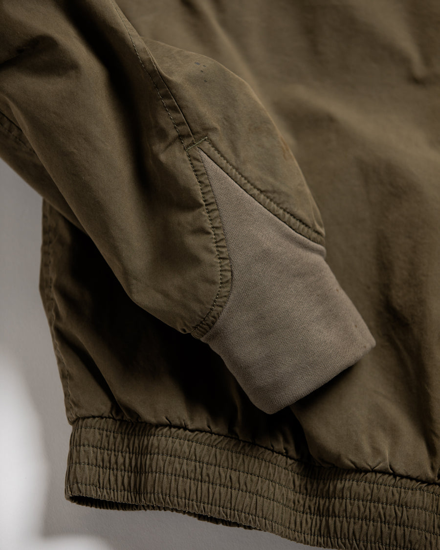 1950年代の希少なフライトジャケットをベースにシルエットを調整し、特徴的なディテールを再現したオリーブカラーのジャケット。
生地にはM1951 ARCTIC OVER PANTSを解析して再現したリプロ素材を使用し、光沢感のあるブライトナイロンを採用。
毛焼きをせずタンブラー仕上げでヴィンテージ感を演出しています。