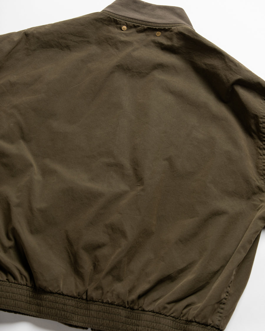 1950年代の希少なフライトジャケットをベースにシルエットを調整し、特徴的なディテールを再現したオリーブカラーのジャケット。
生地にはM1951 ARCTIC OVER PANTSを解析して再現したリプロ素材を使用し、光沢感のあるブライトナイロンを採用。
毛焼きをせずタンブラー仕上げでヴィンテージ感を演出しています。
