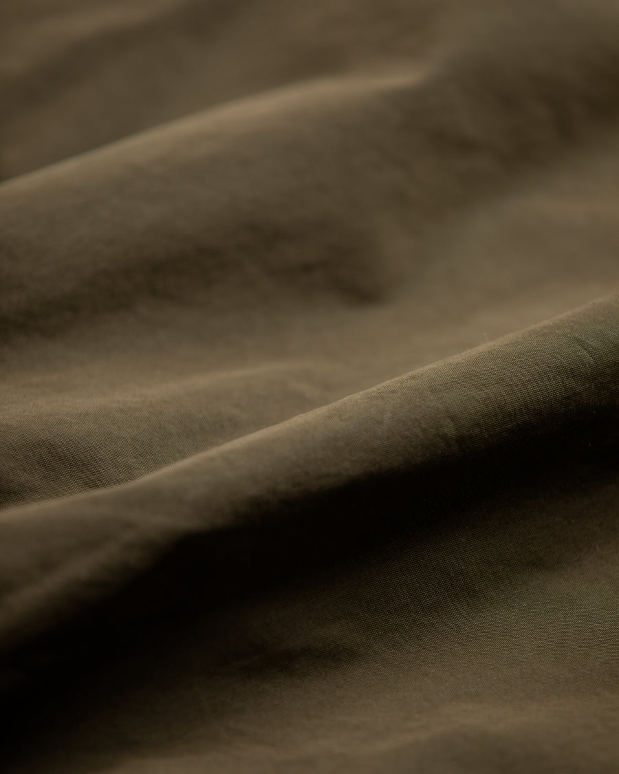 1950年代の希少なフライトジャケットをベースにシルエットを調整し、特徴的なディテールを再現したオリーブカラーのジャケット。
生地にはM1951 ARCTIC OVER PANTSを解析して再現したリプロ素材を使用し、光沢感のあるブライトナイロンを採用。
毛焼きをせずタンブラー仕上げでヴィンテージ感を演出しています。