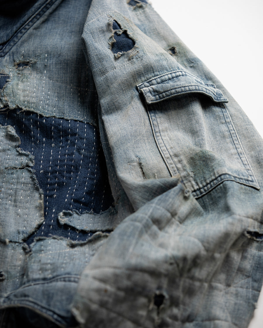ライトオンスデニムを二重縫製で仕立てたフルジップパーカー。
経糸にジンバブエコットン100％、緯糸に綿麻混紡糸を用いたデニムは、シャープなムラ感と粗野な風合いでヴィンテージ感を演出。
全体にエイジングを施し、ハードダメージと手作業のステッチワークで仕上げたリメイク加工が特徴です。