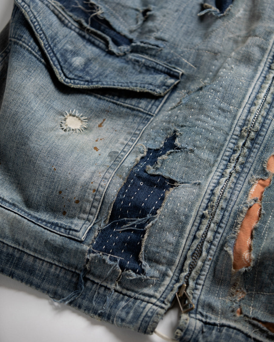 ライトオンスデニムを二重縫製で仕立てたフルジップパーカー。
経糸にジンバブエコットン100％、緯糸に綿麻混紡糸を用いたデニムは、シャープなムラ感と粗野な風合いでヴィンテージ感を演出。
全体にエイジングを施し、ハードダメージと手作業のステッチワークで仕上げたリメイク加工が特徴です。