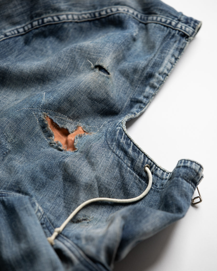 ライトオンスデニムを二重縫製で仕立てたフルジップパーカー。
経糸にジンバブエコットン100％、緯糸に綿麻混紡糸を用いたデニムは、シャープなムラ感と粗野な風合いでヴィンテージ感を演出。
全体にエイジングを施し、ハードダメージと手作業のステッチワークで仕上げたリメイク加工が特徴です。