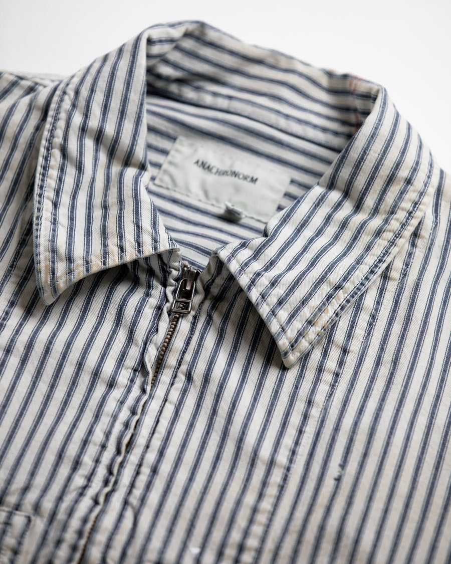 ゆとりある身幅とややクロップド丈でレイヤードを楽しめるデザインにしたヒッコリージャケット。
岡山県製9ozヒッコリーストライプ生地を使用し、ハリのあるしっかりとした風合いが特徴。
全体にエイジングとハードダメージを施し、手作業のステッチ補修とランダムなペンキでリアルな表情に仕上げています。