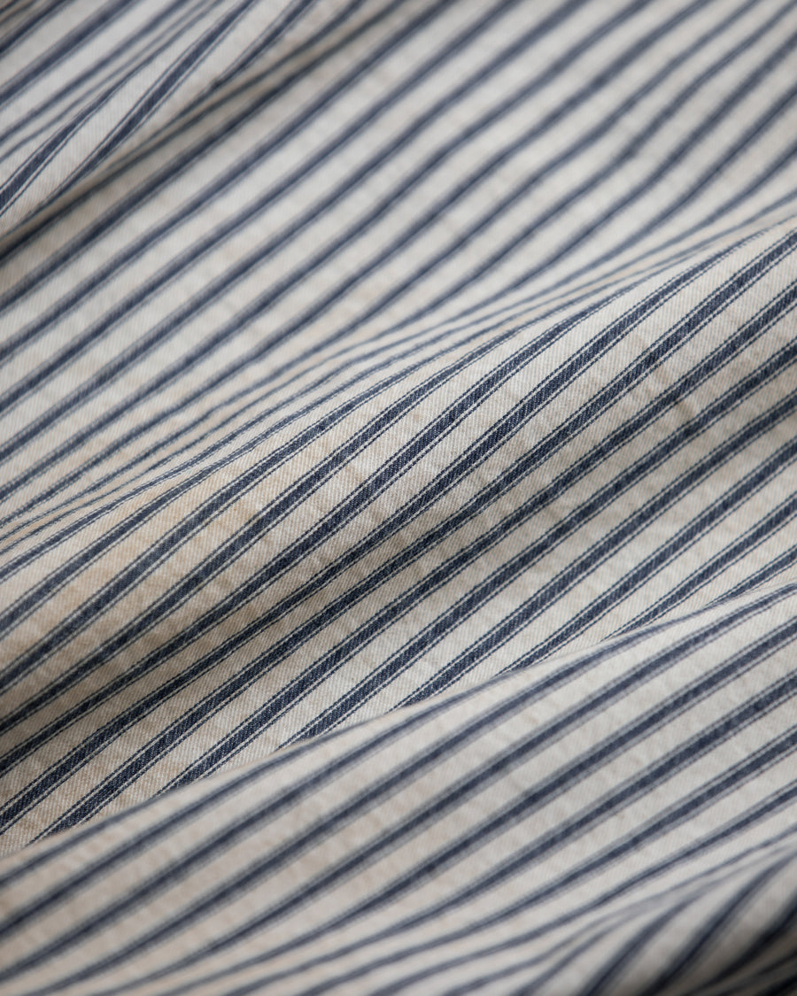 ゆとりある身幅とややクロップド丈でレイヤードを楽しめるデザインにしたヒッコリージャケット。
岡山県製9ozヒッコリーストライプ生地を使用し、ハリのあるしっかりとした風合いが特徴。
全体にエイジングとハードダメージを施し、手作業のステッチ補修とランダムなペンキでリアルな表情に仕上げています。